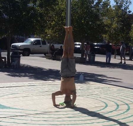 man performing a handstand at the centre of a labyrinth